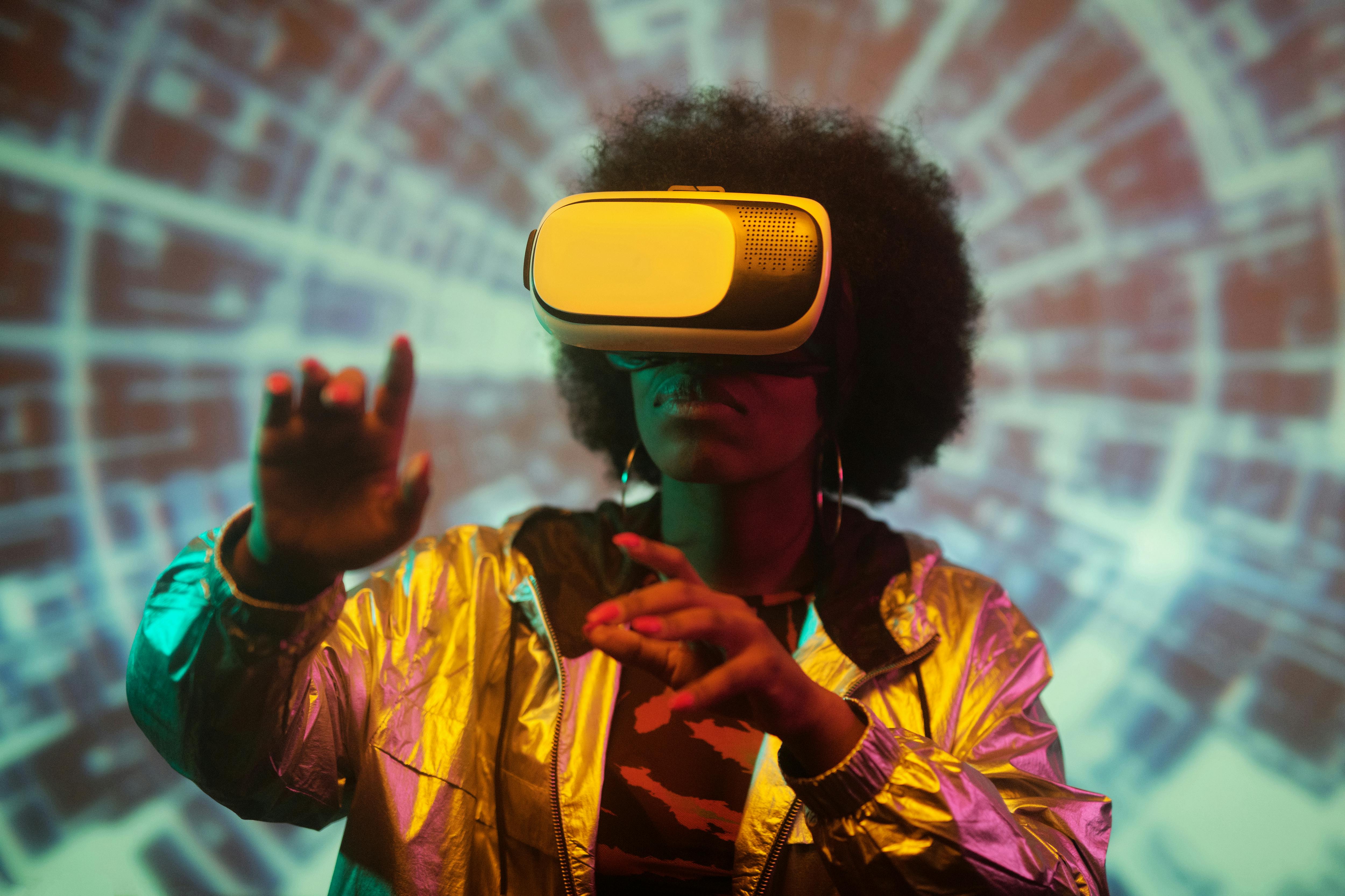Woman with afro hairstyle wearing a VR headset interacting with virtual elements in colorful light.